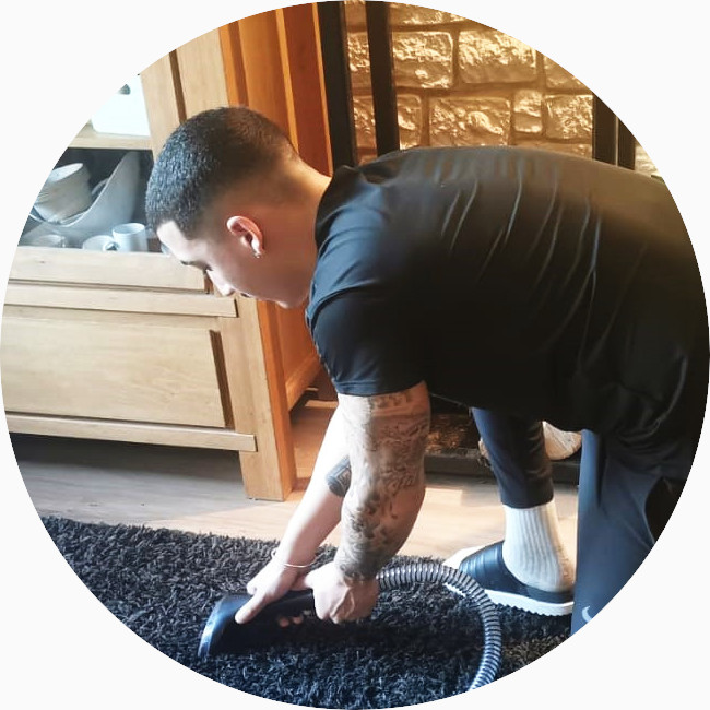 JB Clean réalisant une prestation de nettoyage sur un tapis de salon avec son aspirateur professionnel